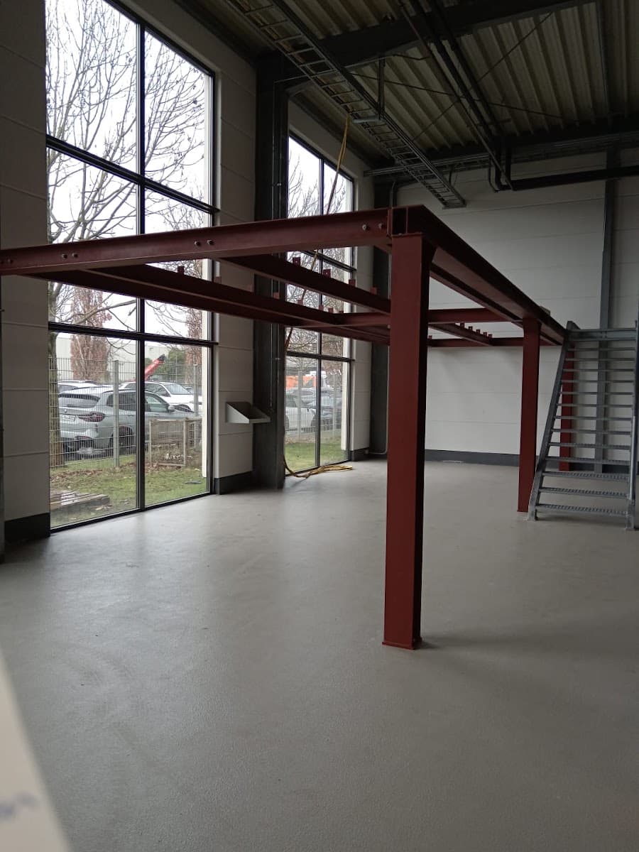 Leere Gewerbehalle mit roter Stahlkonstruktion für ein Zwischengeschoss