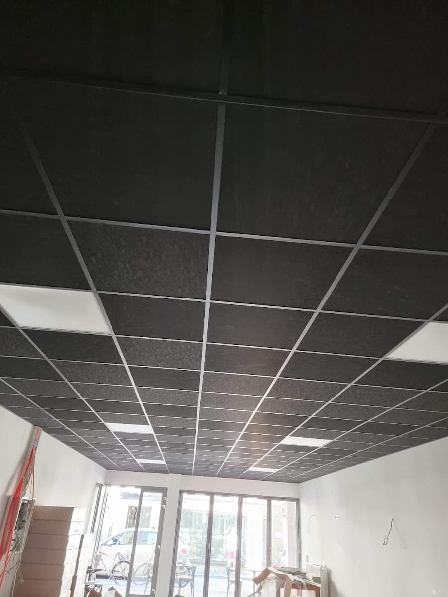 Schwarze Rasterdecke mit LED-Panels in einem Ladenlokal